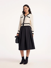 a lady in plus size black a-line skirt with cardigan